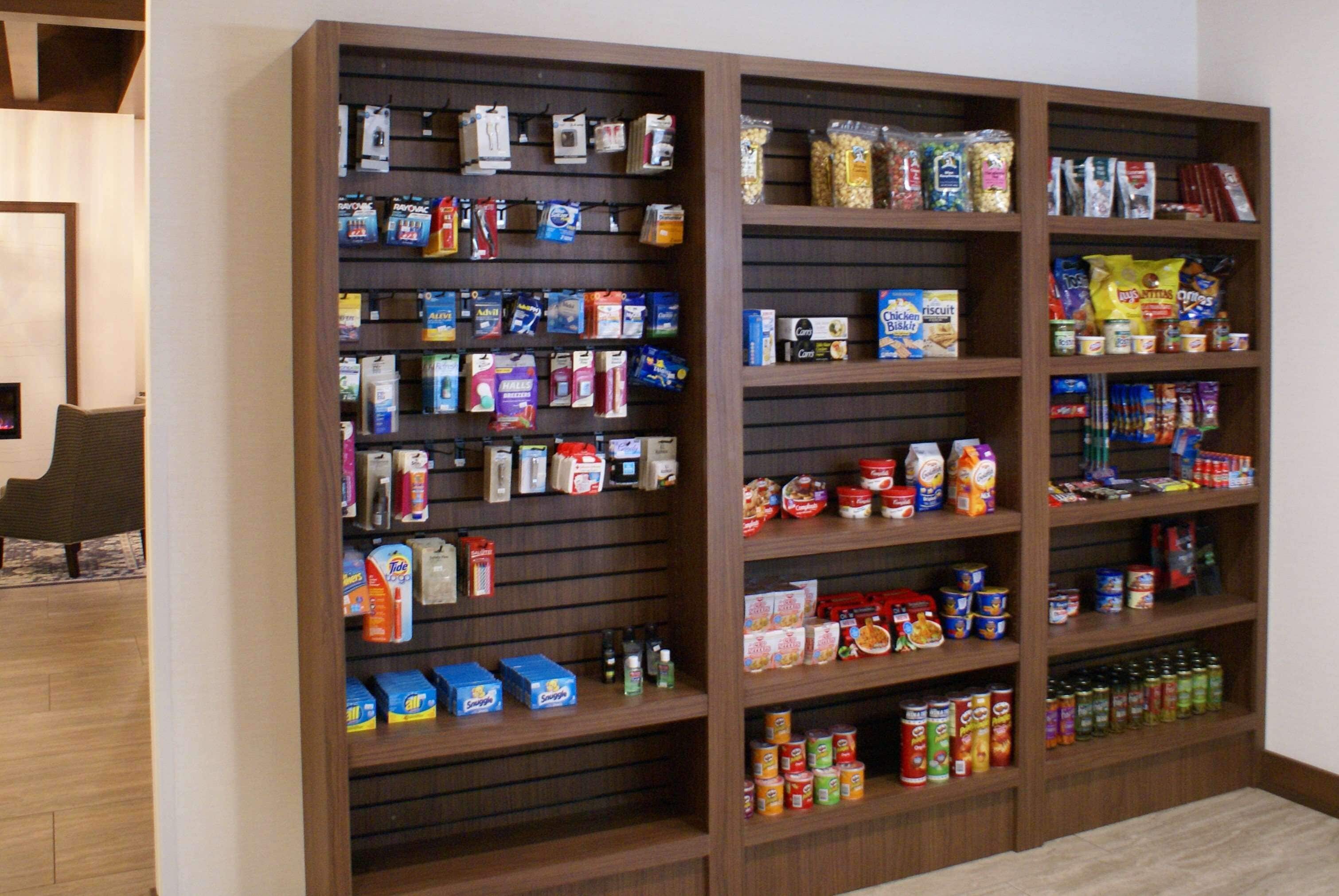 A large wooden shelving unit stocked with various food items and household products.