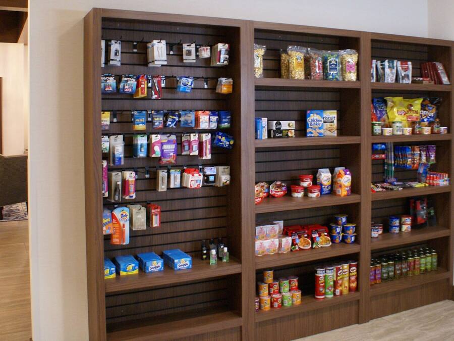 A large wooden shelving unit stocked with various food items and household products.
