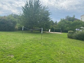 A grassy outdoor area with a swing set and a netted play area. - Kyriad ECO - Marne-la-Vallée Bussy-Saint-Georges (Bussy-Saint-Georges)