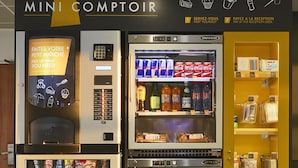 A vending machine with a variety of snacks and beverages, a Coca-Cola refrigerator, and a Mini Comptoir sign. - Kyriad ECO - Marne-la-Vallée Bussy-Saint-Georges (Bussy-Saint-Georges)