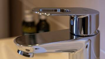 A chrome faucet with a single lever handle on a white countertop.