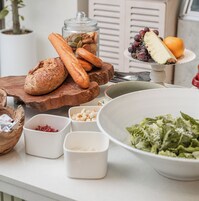 A table with various food items including bread, nuts, and a salad.