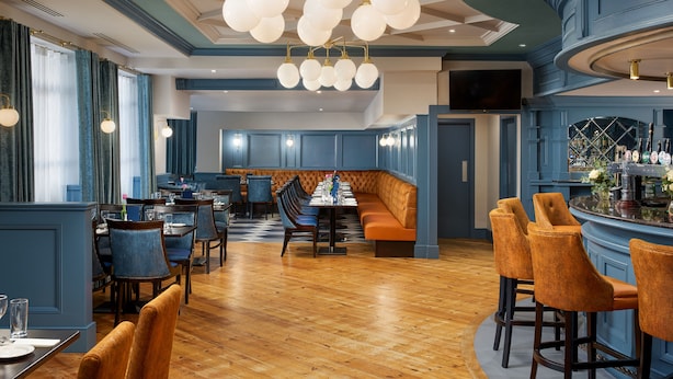 A restaurant with a bar area, wooden flooring, and blue walls. - Springfield Hotel (Leixlip)