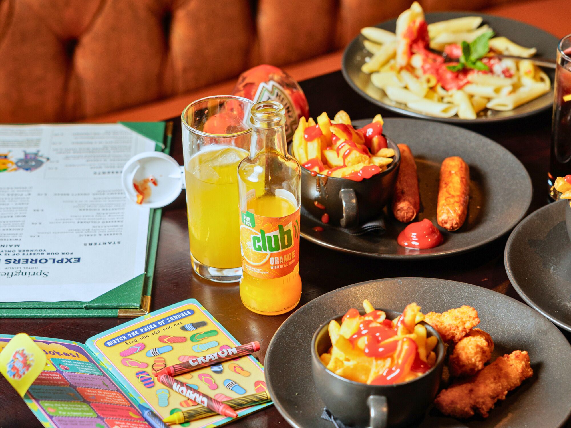 A table with food items, a drink, and a board game.