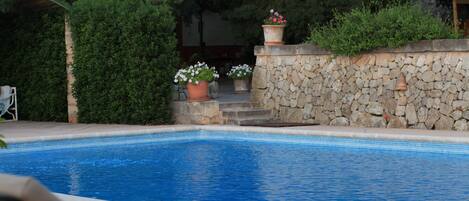 Alberca al aire libre, sombrillas en la alberca y camastros