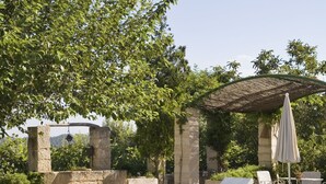 A pool area with lounge chairs, a pergola, and a stone structure. - Agroturismo sa Rota den Palerm (Lloret de Vistalegre)