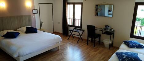 A hotel room with a bed, desk, chair, and a balcony view.