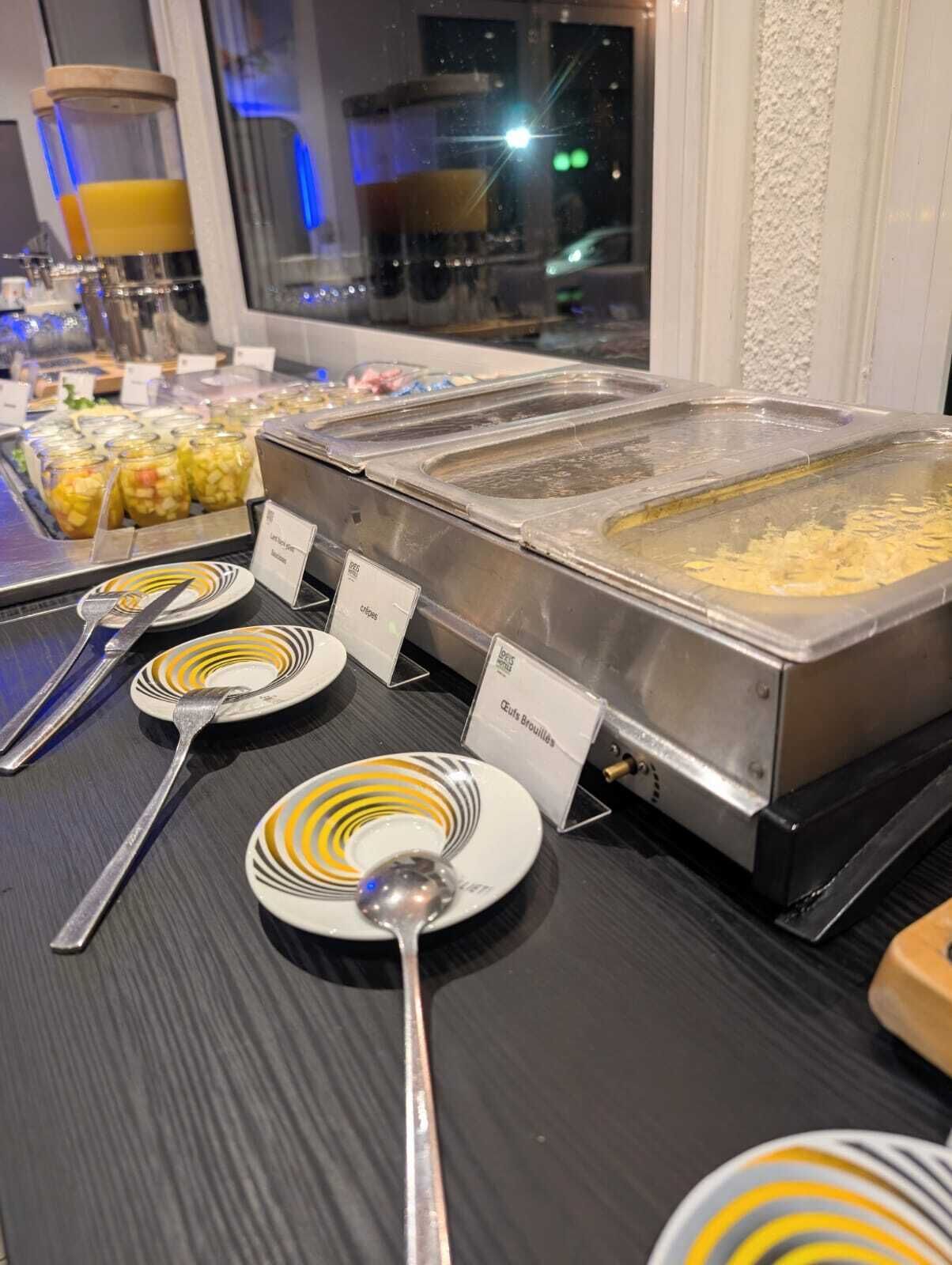 Buffet com alimentos identificados e utensílios.