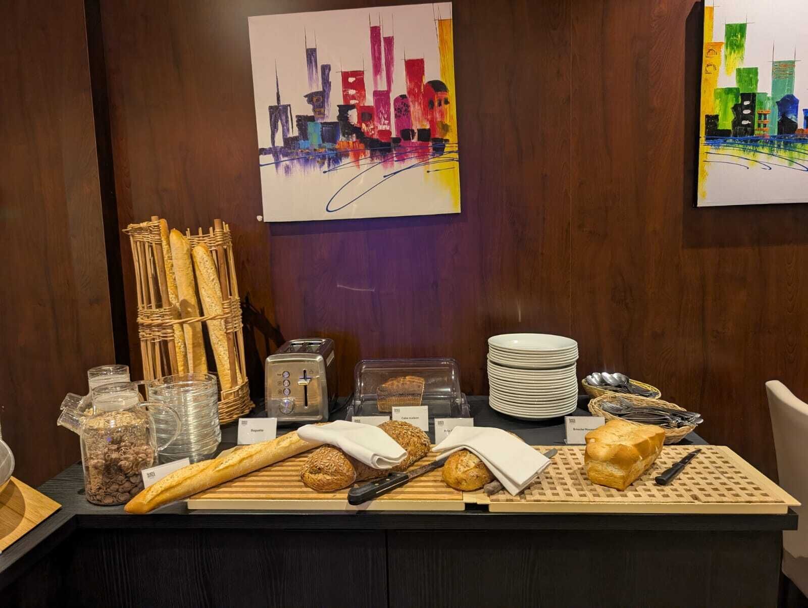 Un buffet de petit-déjeuner comprenant du pain, des viennoiseries et un grille-pain.