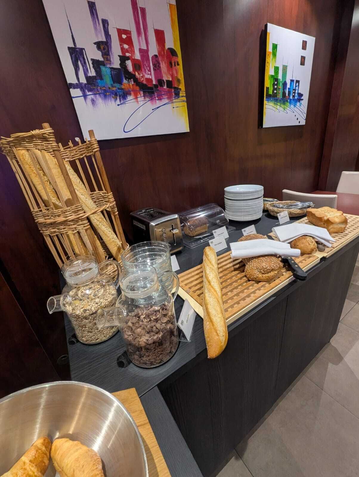 Disposición de bufé con diversas opciones de comida, un tostador y una cafetera.