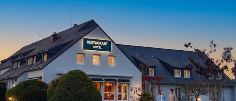 A two-story building with a sign reading 'RESTAURANT HOTEL.'