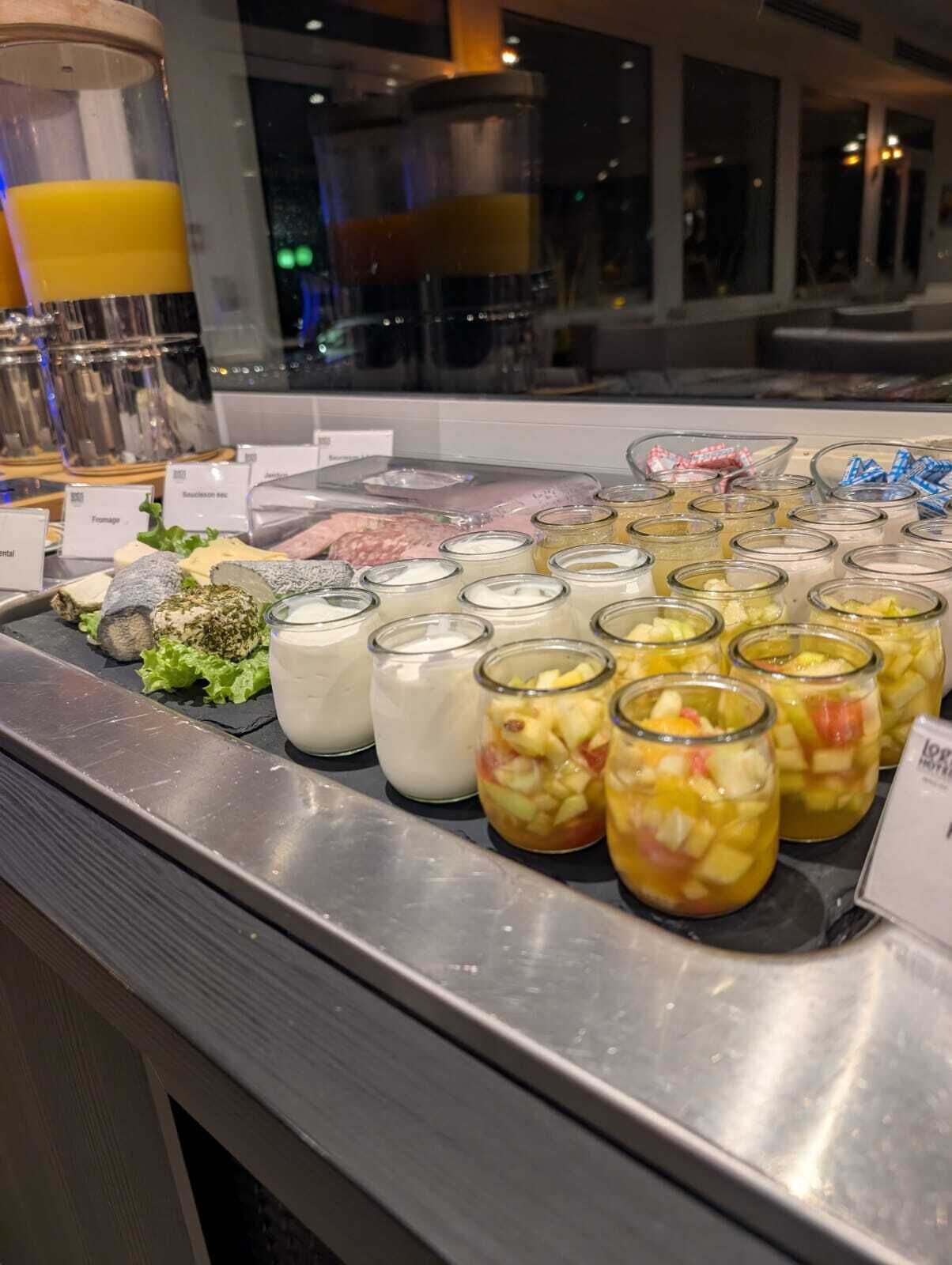 Un bufé con diversos alimentos, entre ellos frutas, productos lácteos y carnes.