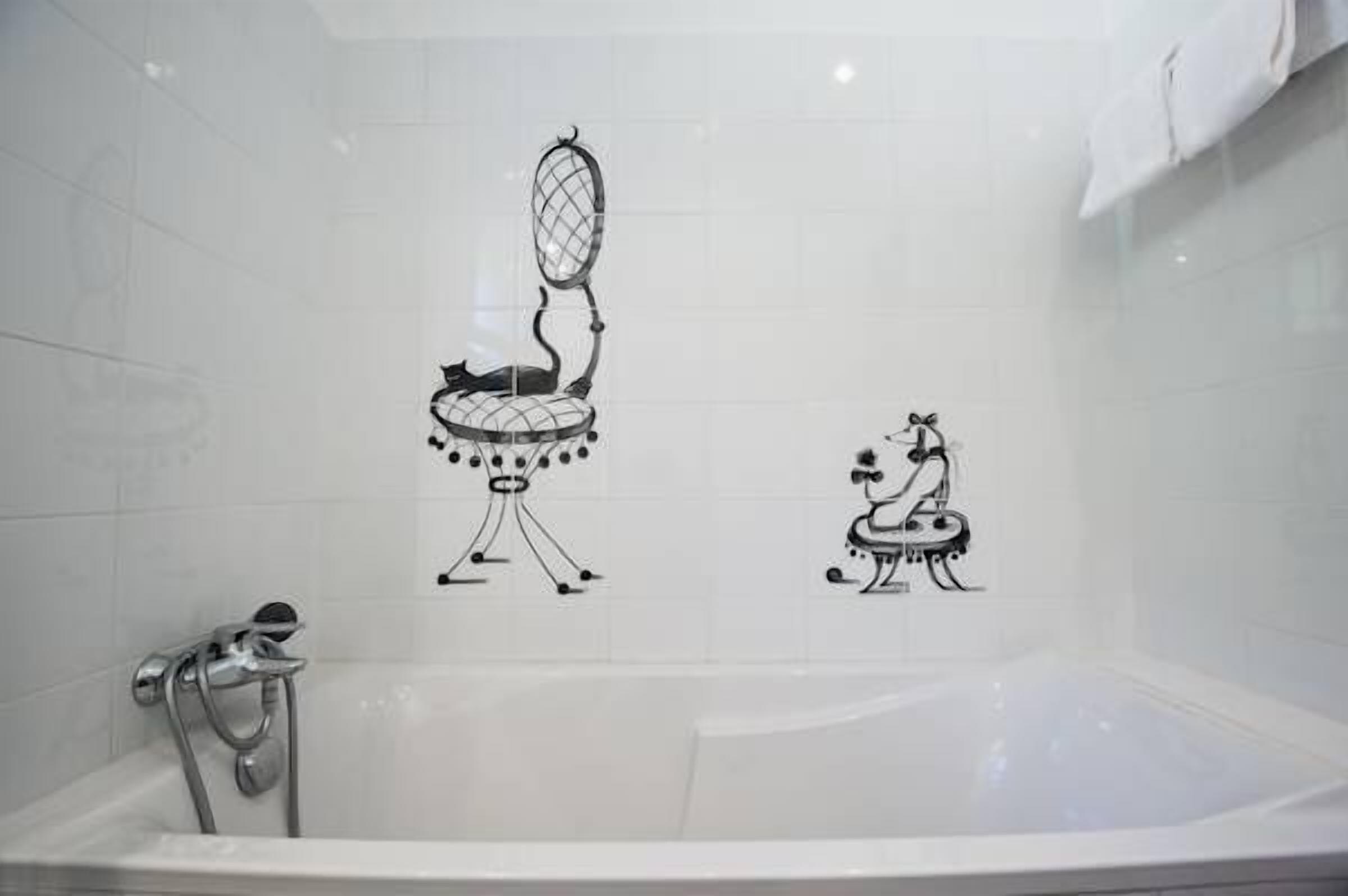 A bathroom with a white bathtub, a shower, and a towel rack.