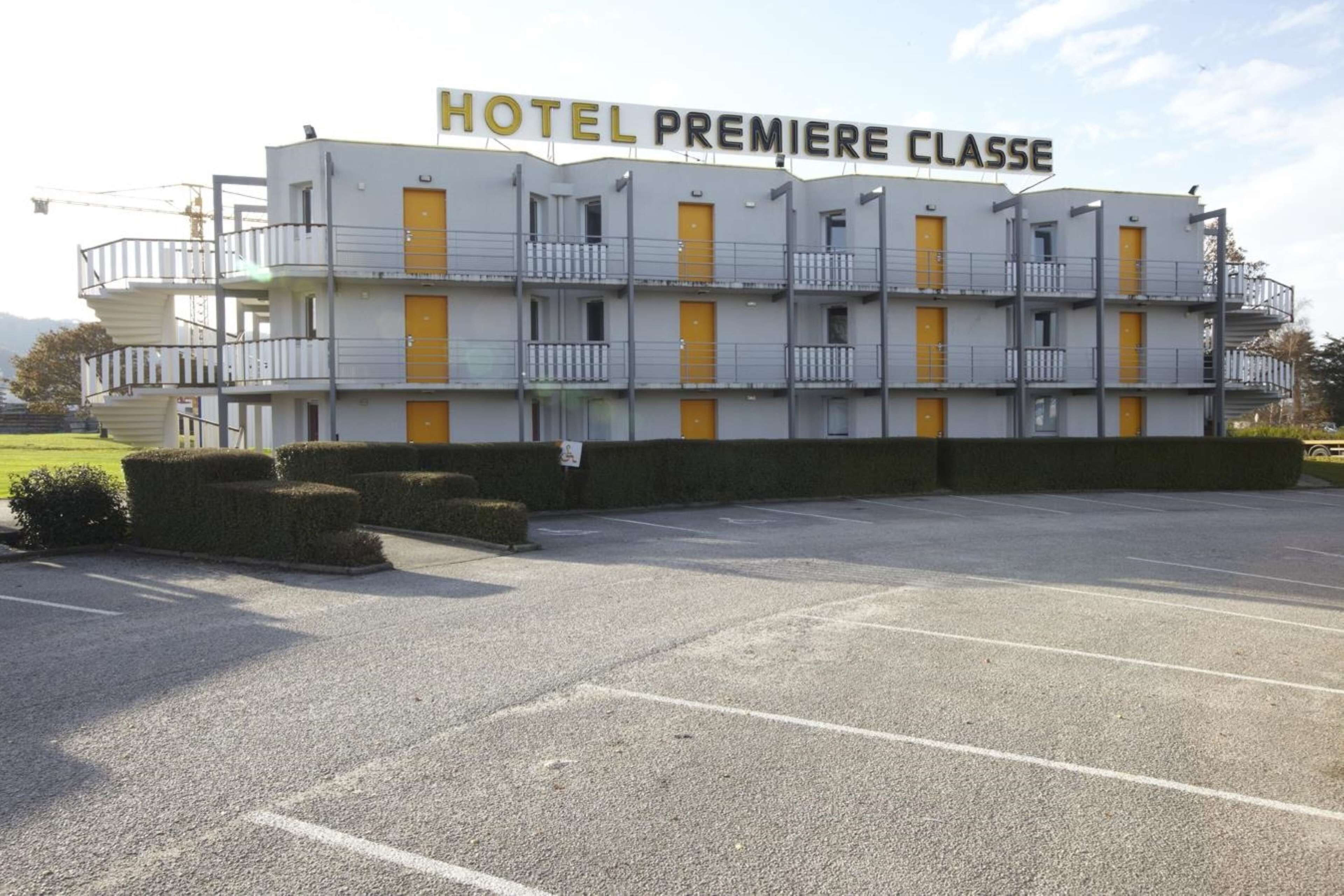 Ein mehrstöckiges Hotelgebäude mit Balkonen und gelben Türen.