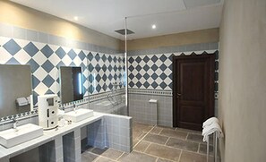 A bathroom with a large mirror, a sink, and a shower area.