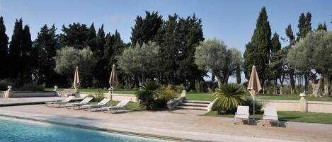 Outdoor pool, a waterfall pool, open 7 AM to 10 AM, pool umbrellas