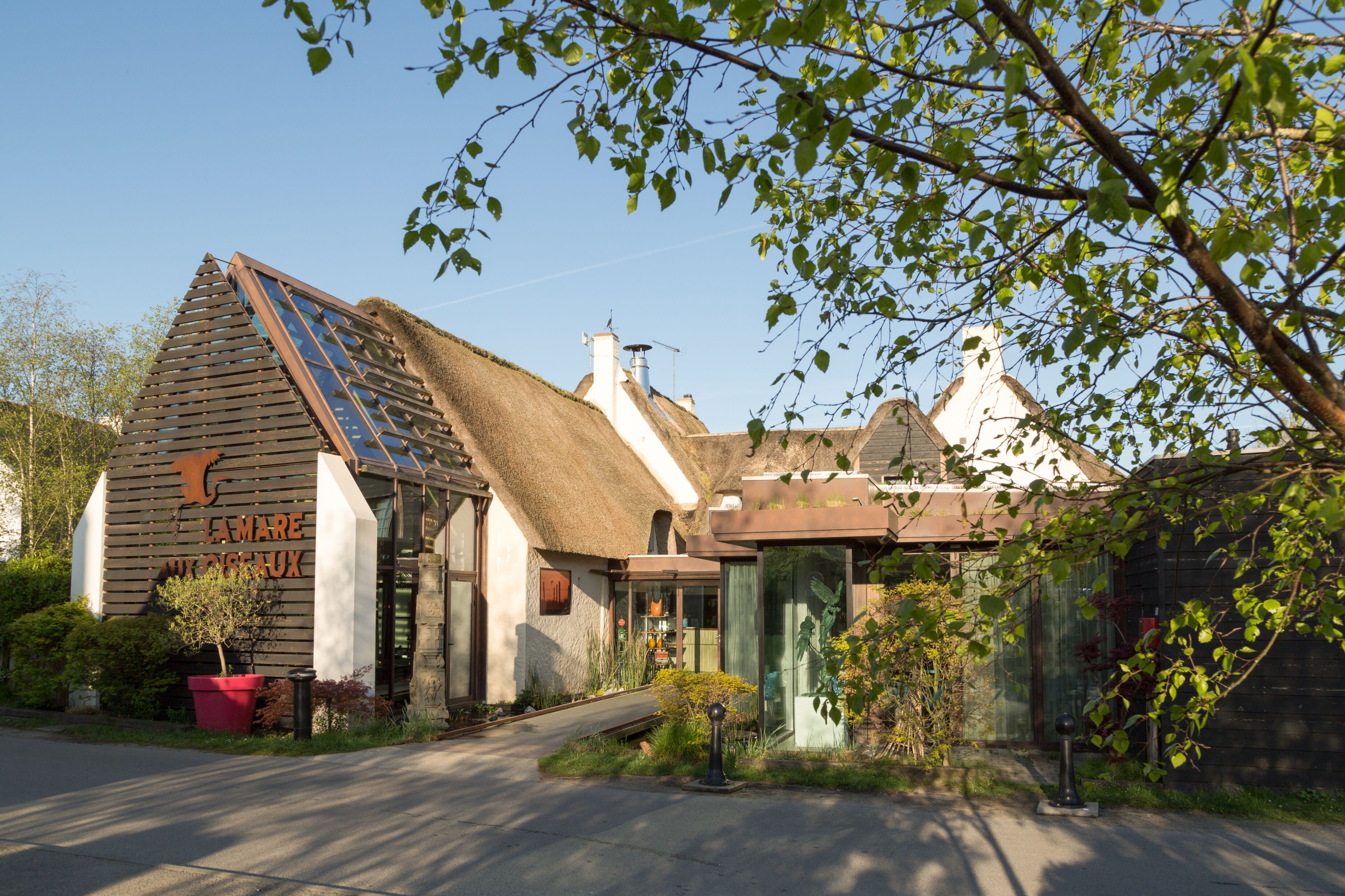 A traditional building with a sloped roof, a visible chimney, and a sign that reads "LAMARE".