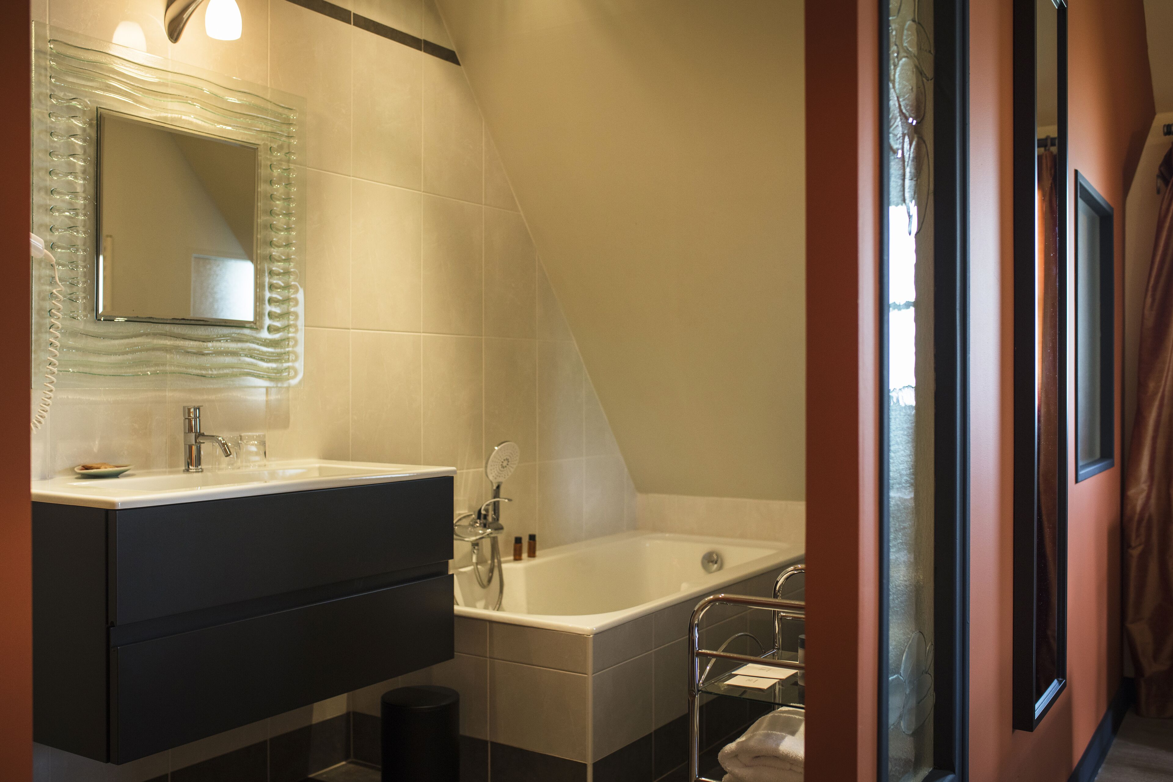 Une salle de bain moderne avec une douche à parois de verre, une grande baignoire et un meuble-lavabo avec un miroir.