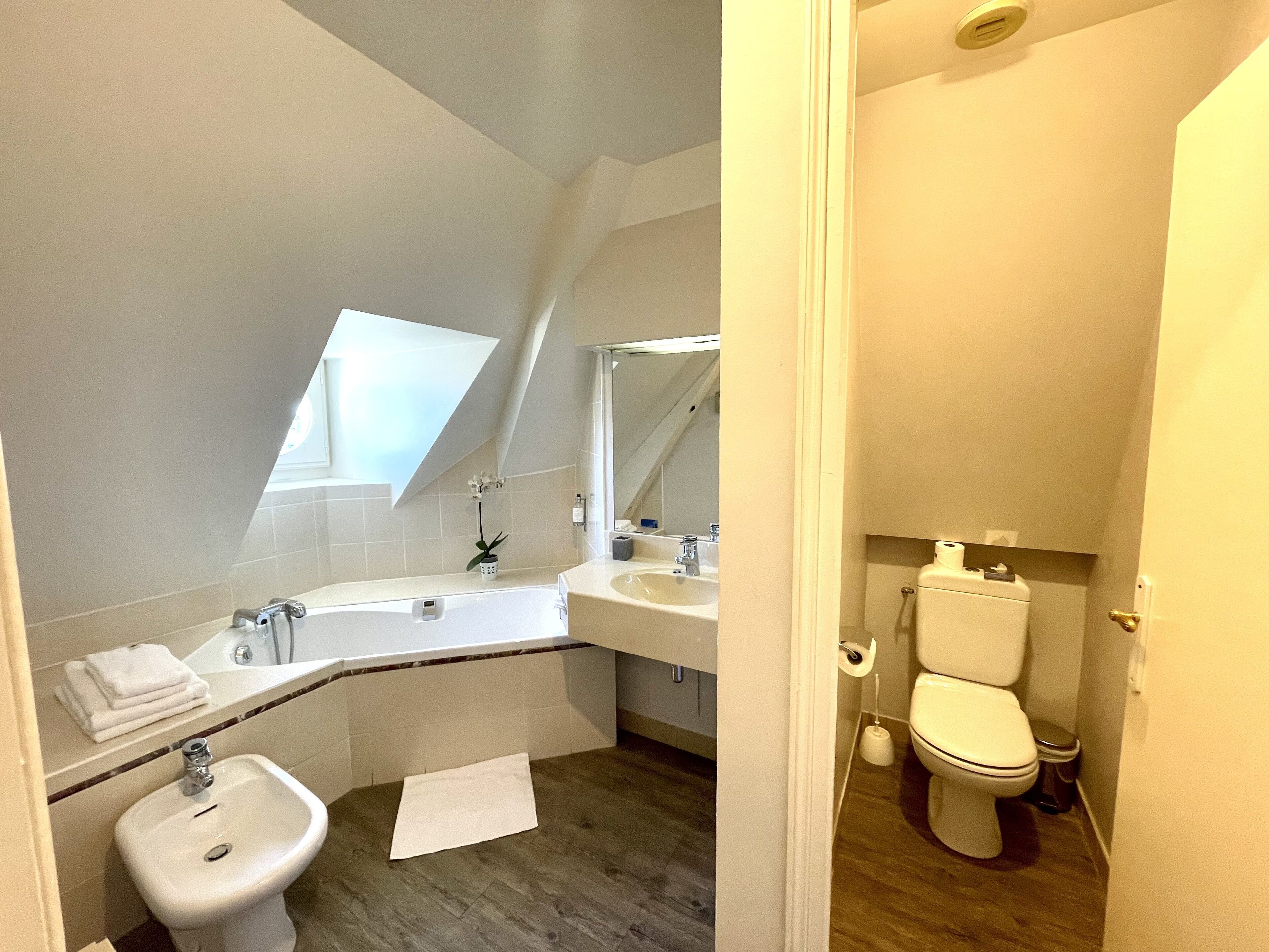 Een moderne badkamer met een toilet, wastafel en bidet.