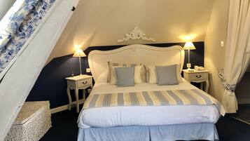 Un dormitorio con cama, dos mesitas de noche, una lámpara y un cabecero decorativo.