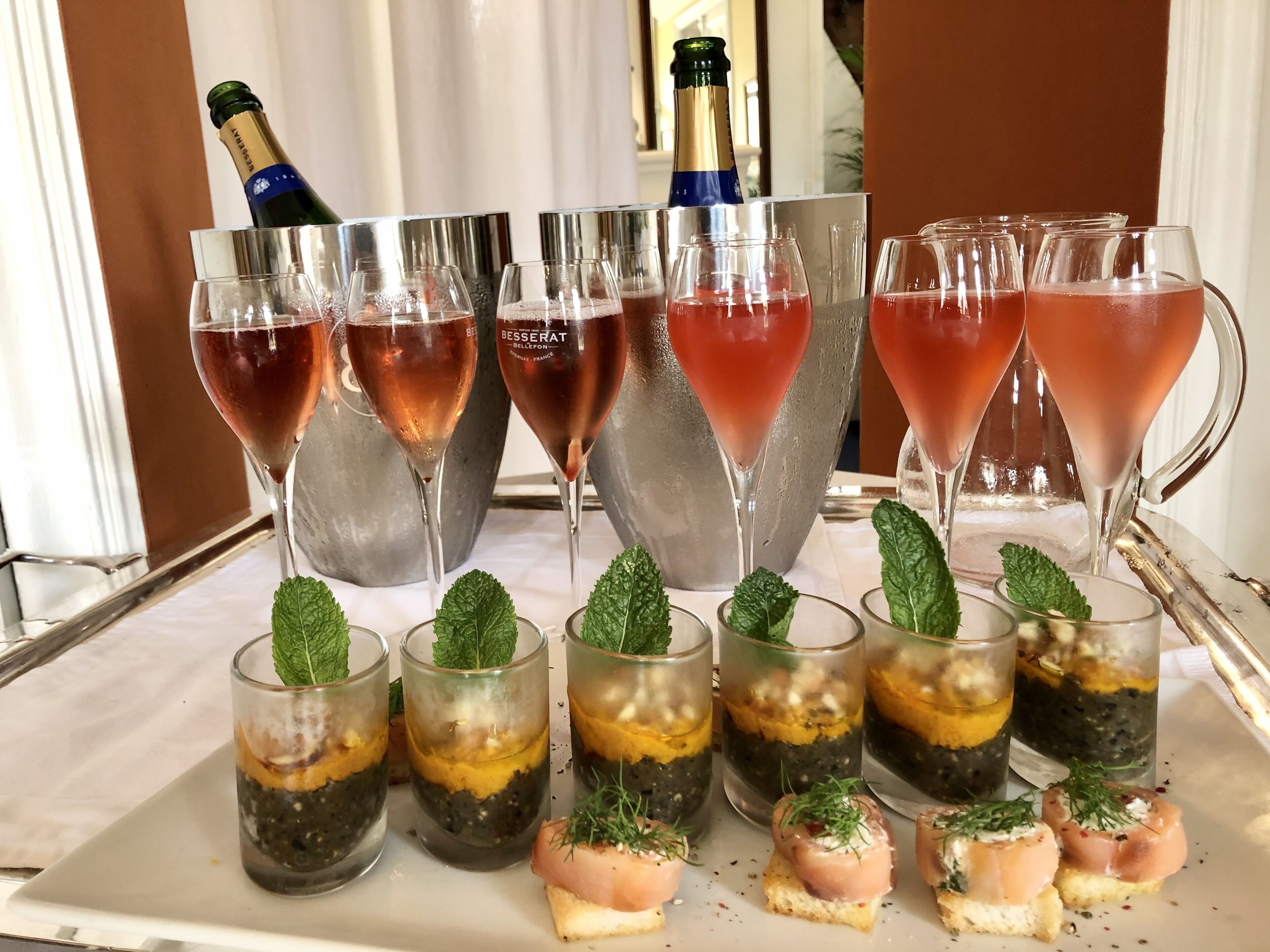 A table with champagne glasses and a bottle, garnished with mint leaves.