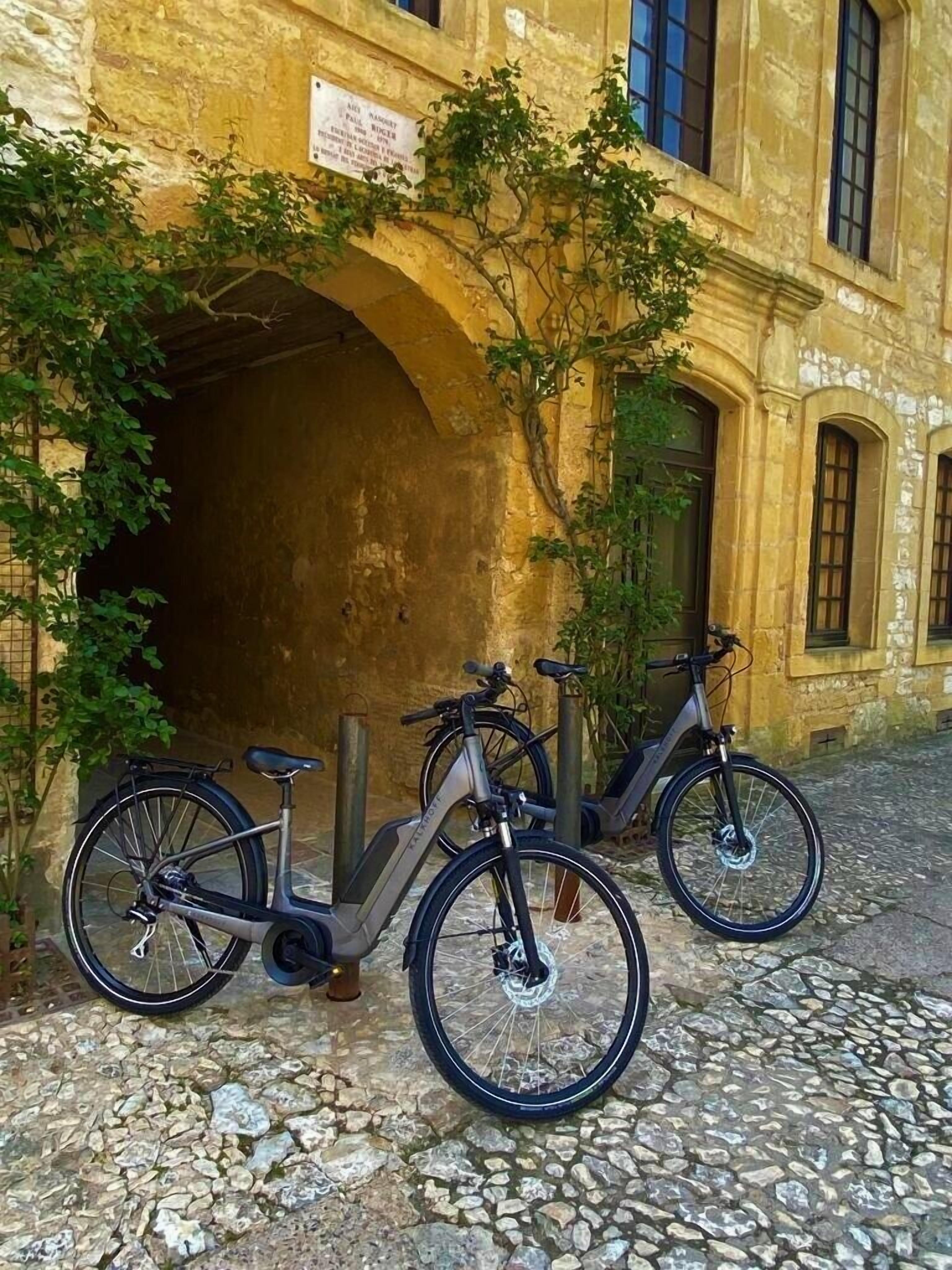 Un edificio con una entrada abovedada y dos bicicletas estacionadas frente a él.
