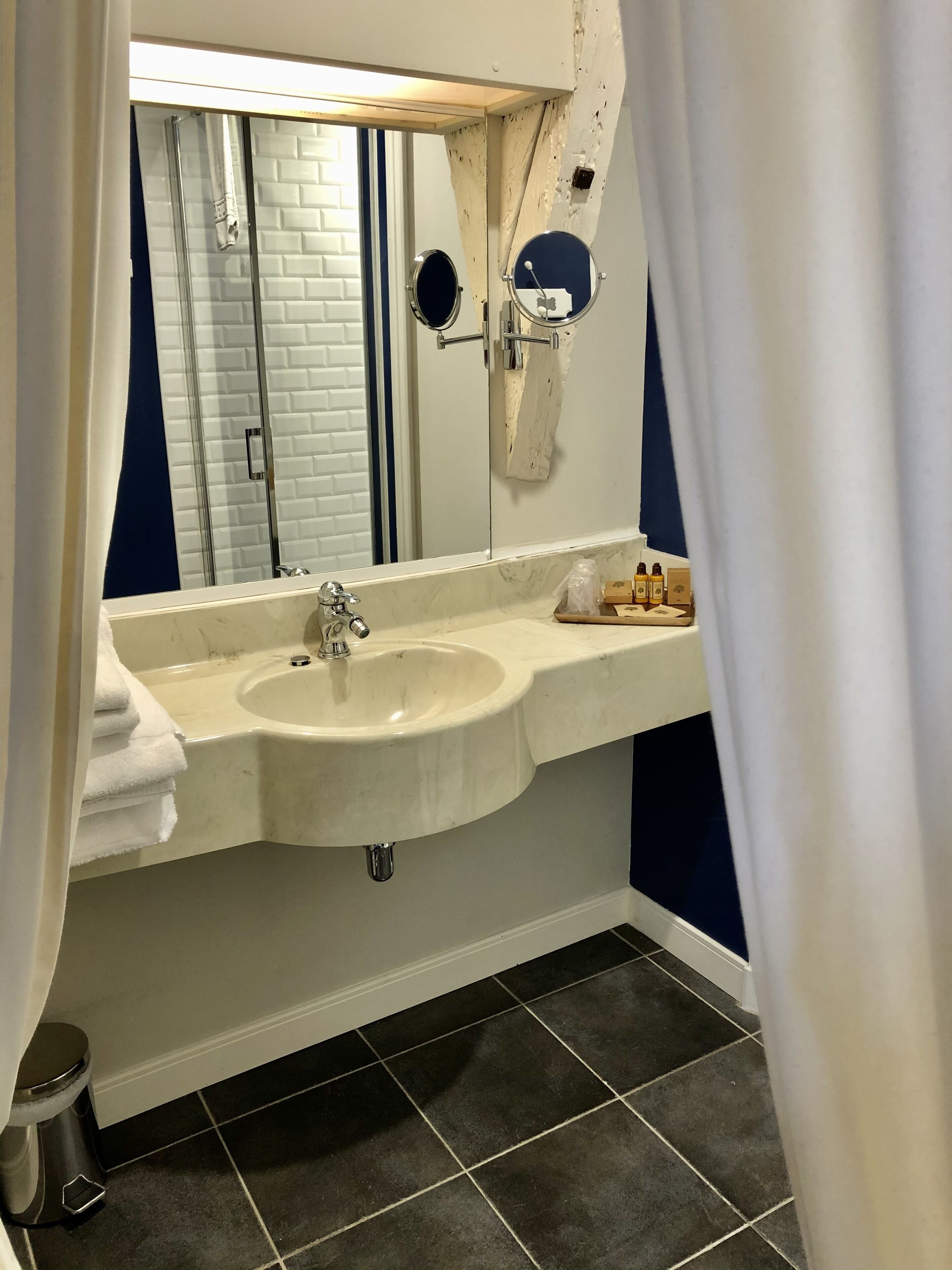 A bathroom with a white sink, a mirror, and a shower area.
