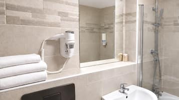 Un baño moderno con secador de pelo, lavabo y ducha.