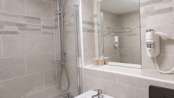 Une salle de bain moderne avec une douche, un lavabo et un miroir.
