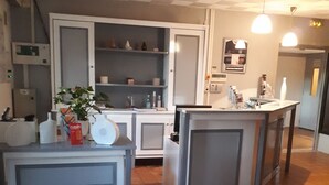 A kitchen with a central island, white cabinets, and a tiled floor. - Kyriad - Narbonne Sud (Narbonne)
