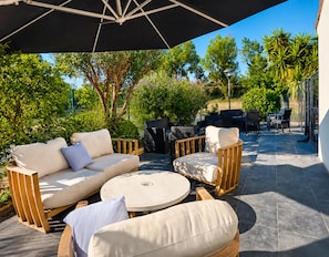 An outdoor patio with a sofa, chairs, and a round table. - Kyriad - Narbonne Sud (Narbonne)