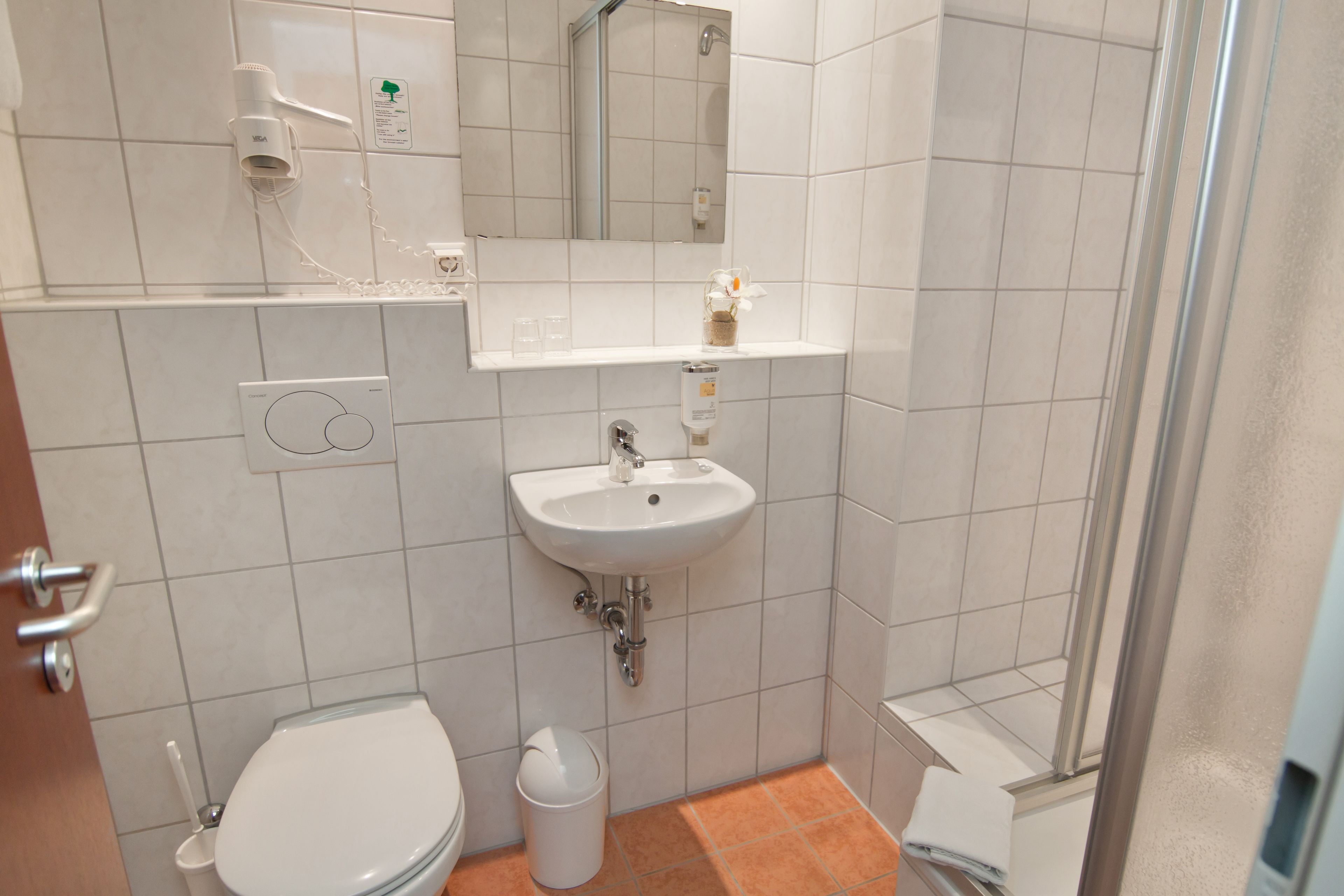 A bathroom with a toilet, sink, and shower.