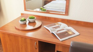 Ein Holztisch mit Spiegel, zwei kleinen Topfpflanzen und einer offenen Zeitschrift.