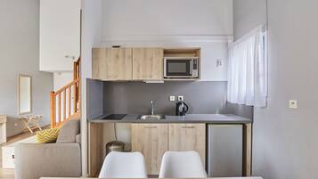 A compact kitchen with a microwave, sink, and wooden cabinets.