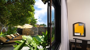 Une chambre avec vue sur une piscine, des chaises longues et un coin repas.