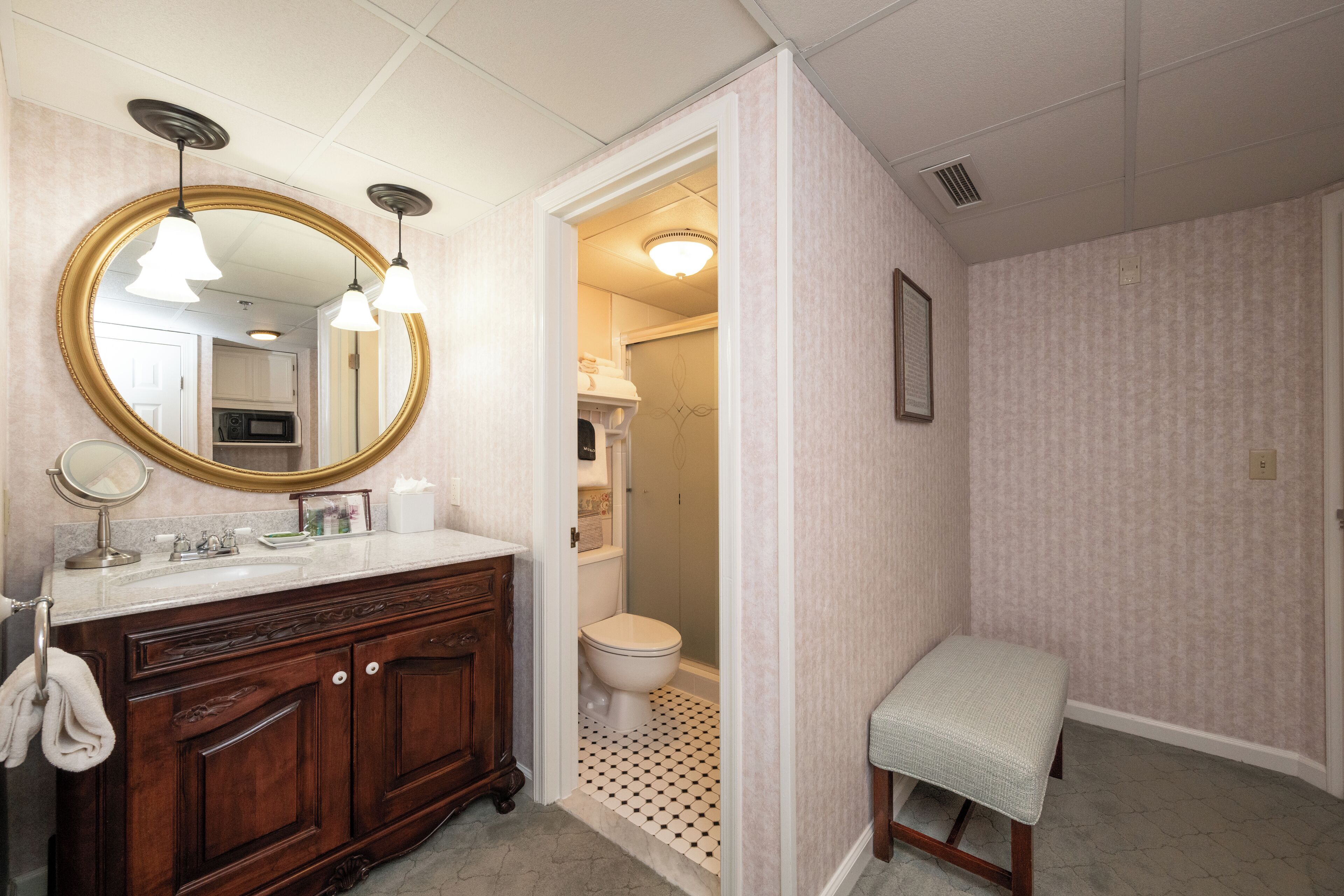 Ein Badezimmer mit einem Holzlagerflächen, einem großen Spiegel und einer Toilette.