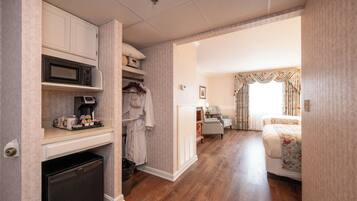 Ein kompaktes Hotelzimmer mit Küchenzeile, einem Bett, einer Sitzecke und einem Badezimmer.