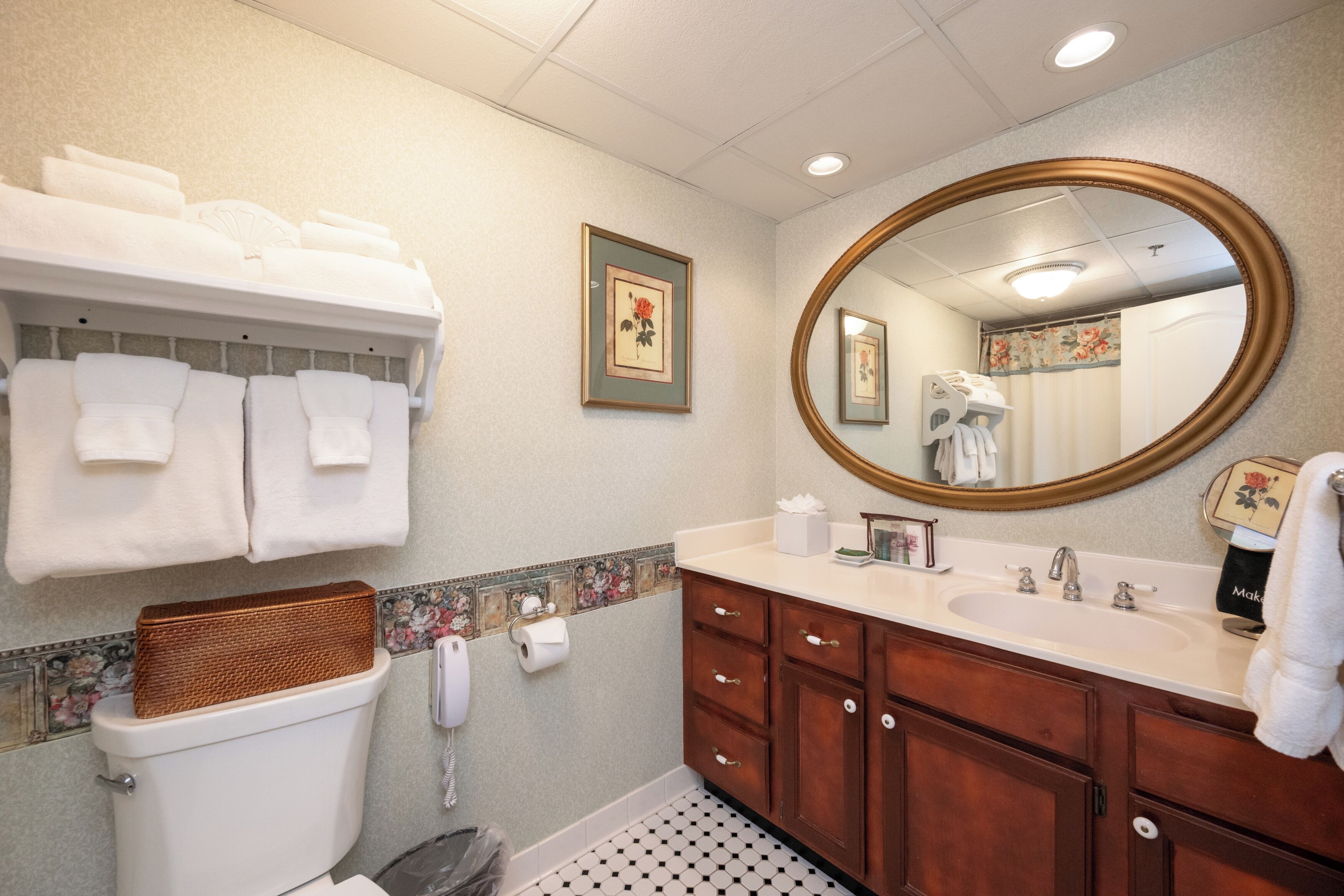 Een badkamer met toilet, wastafel, spiegel en handdoekhouder.