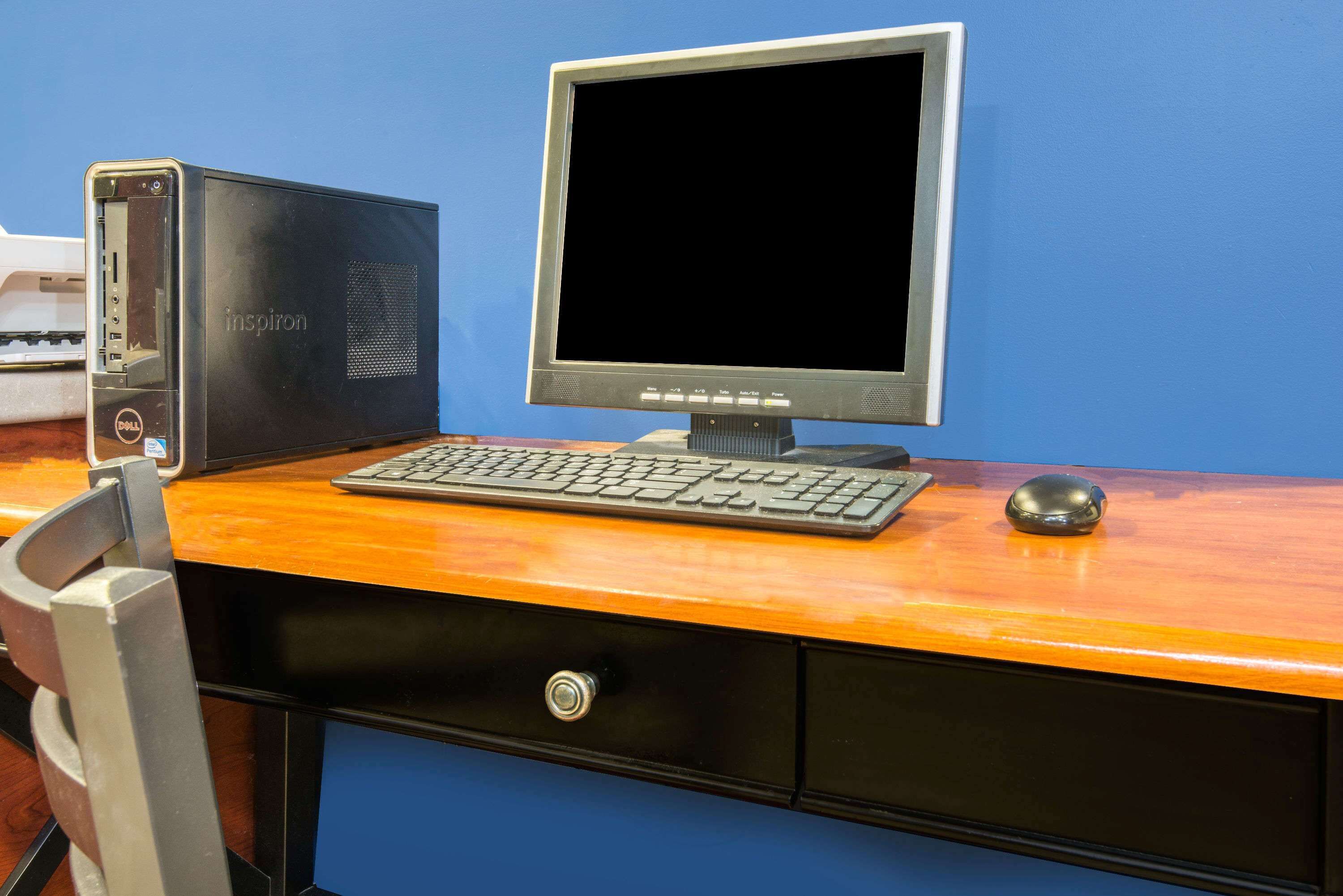 A computer desk with a desktop computer, keyboard, and mouse.