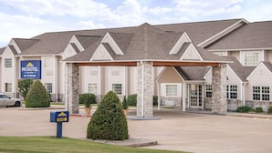 A Microtel Inn & Suites building with a covered entrance, multiple windows, and a parking lot. - Microtel Inn & Suites by Wyndham Miami (Miami)