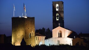 Un edificio histórico con una torre de campanas y un asta de bandera.