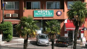 Un hotel de varios pisos con balcones y un letrero que dice 'HOTEL PANORAMA'.