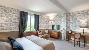 Une chambre d’hôtel avec un grand lit, un bureau, une chaise, une télévision et une lampe.