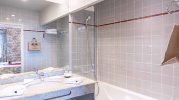 Un baño moderno con ducha envuelta en vidrio, lavamanos de mármol y bañera.