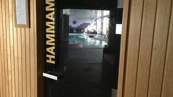 Una puerta de madera con la palabra "HAMMAM" que indica una zona de sauna.