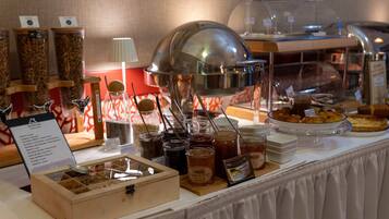 A buffet with various food items and condiments.