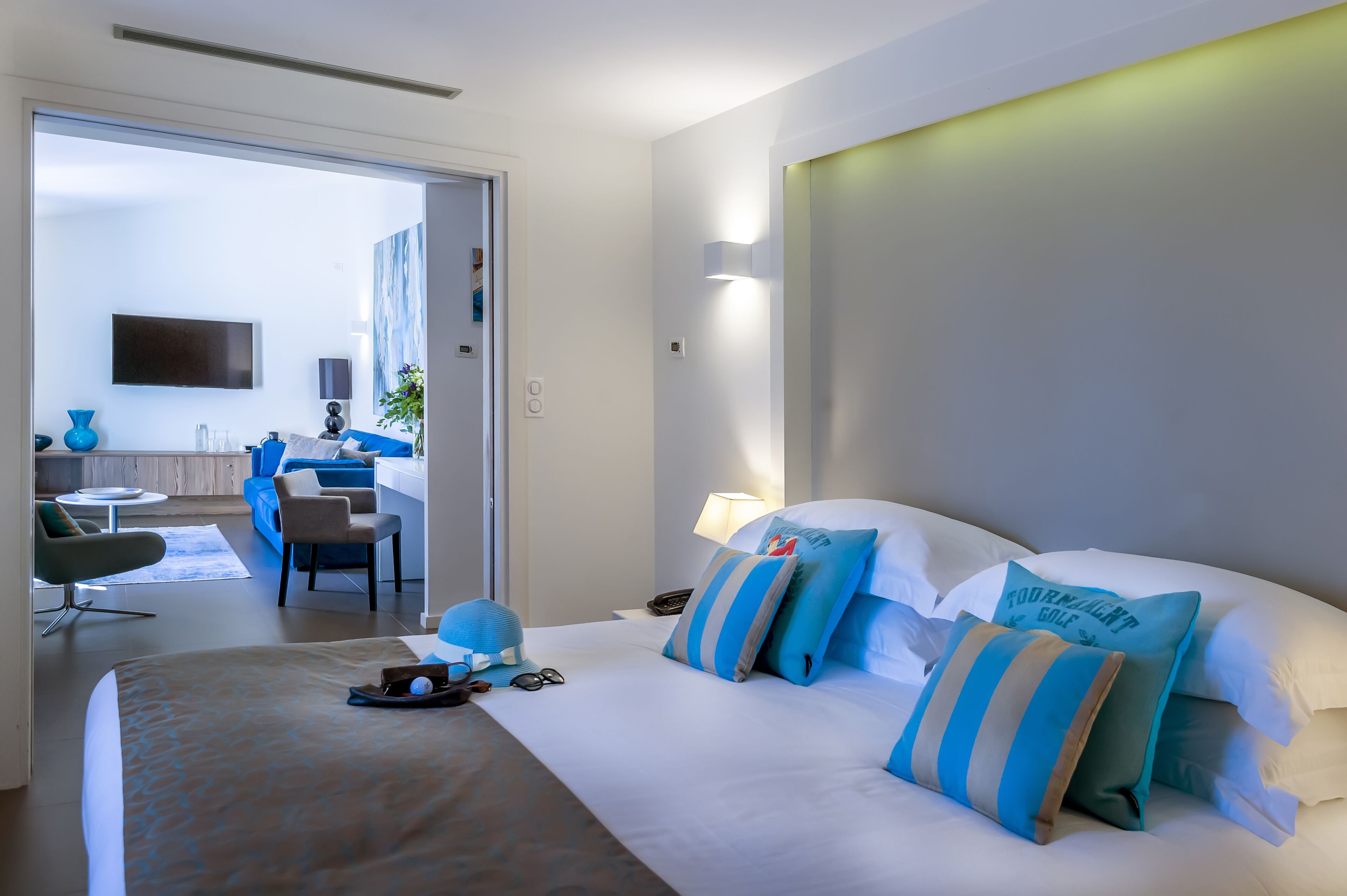 A modern hotel room with a large bed, a desk, and a seating area.