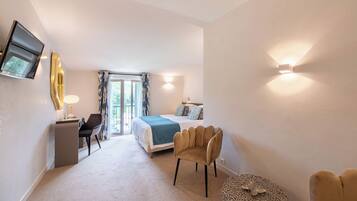 Une chambre d’hôtel moderne équipée d’un lit, d’un bureau, d’une chaise et d’un pouf rond.