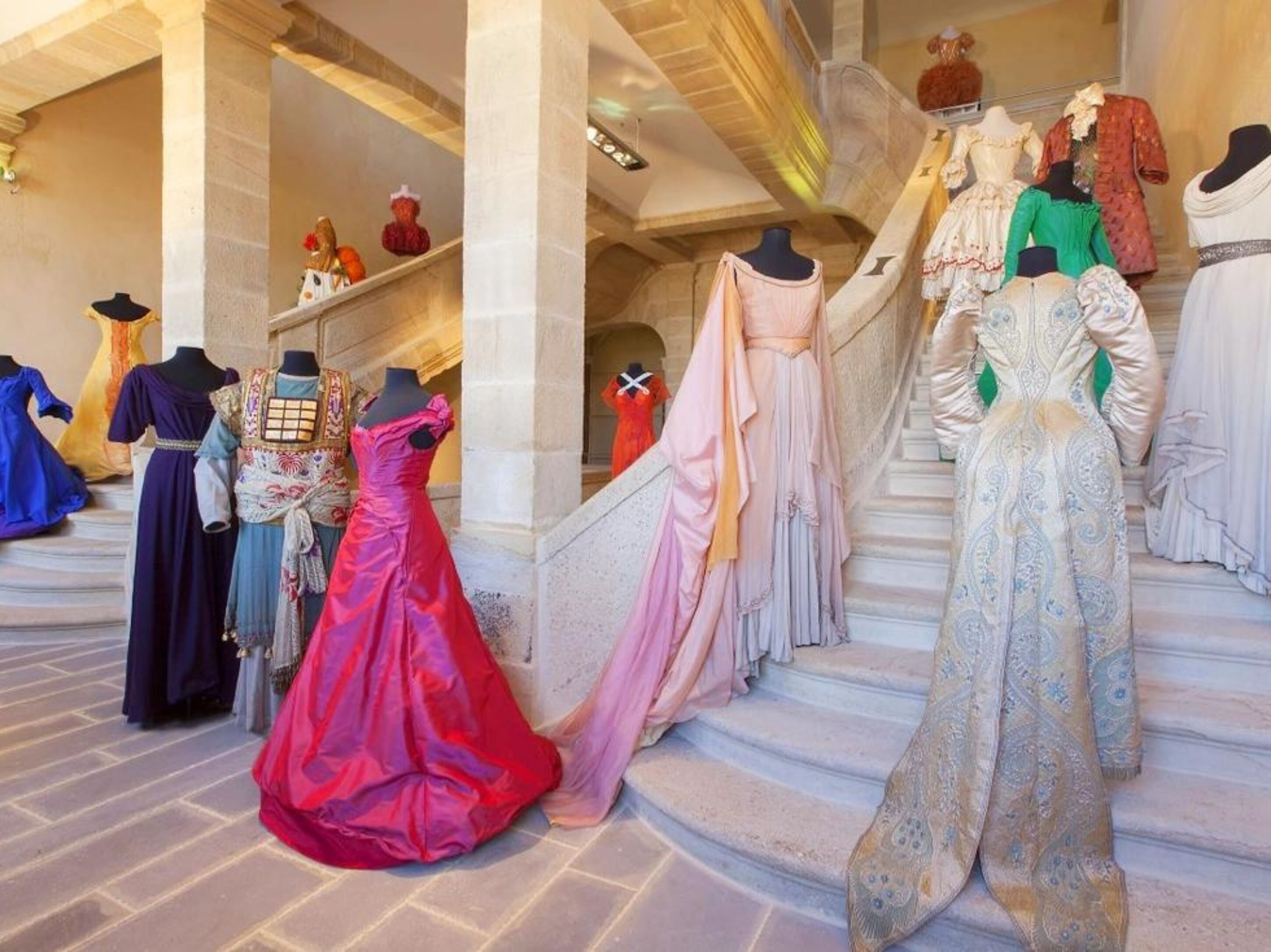 A staircase with mannequins dressed in various historical costumes.