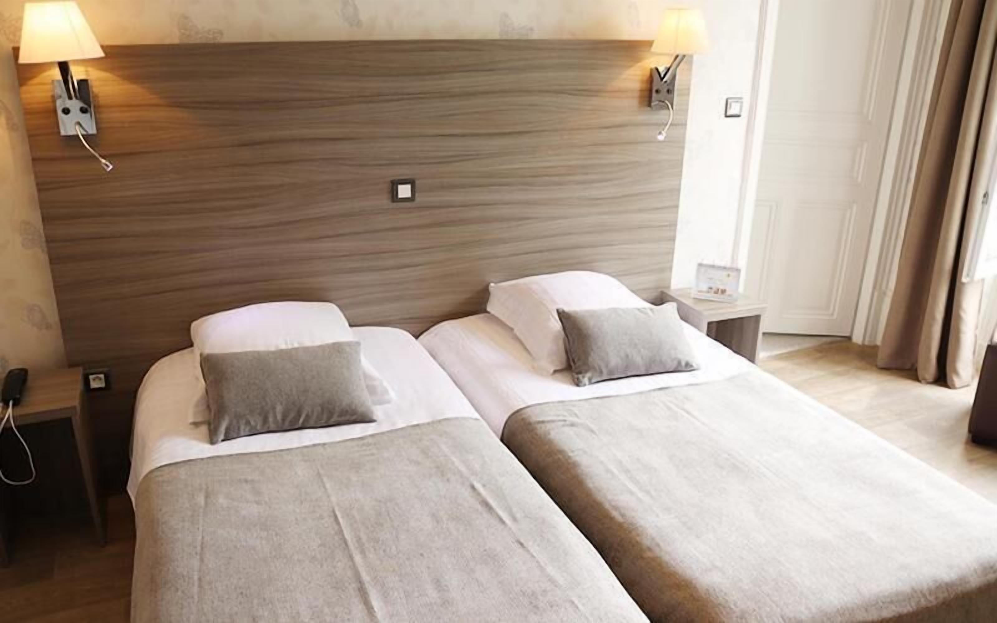 A double bed with a wooden headboard, two bedside tables, and a lamp on each side.